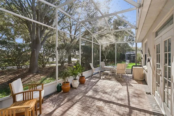 a view of a patio with couches and chairs under an umbrella