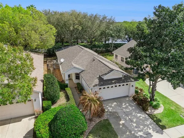 an aerial view of a house with a yard and large trees