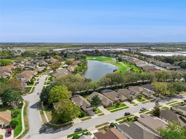 an aerial view of ocean and residential houses with outdoor space