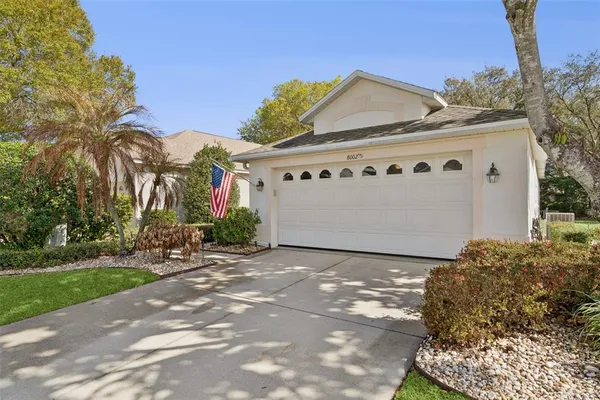a view of a white house with a yard and potted plants
