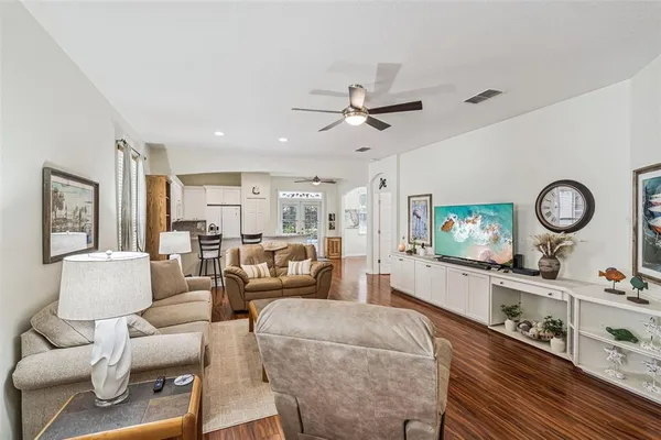 a living room with furniture a flat screen tv and a window