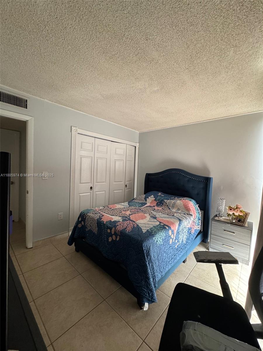2410 Southwest 122nd Court, Unit 1 Miami, FL 33175 - Photo 18 of 26 a bedroom with a bed and a table in it