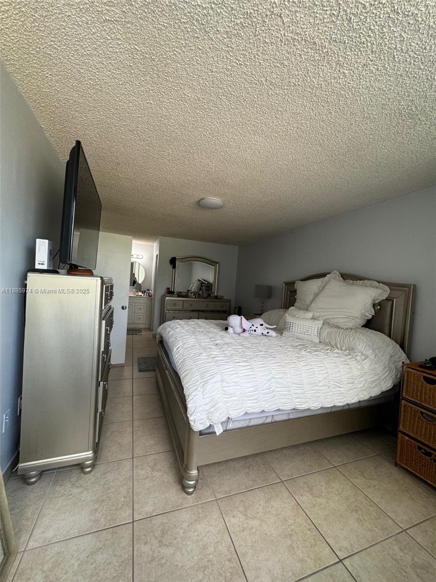 2410 Southwest 122nd Court, Unit 1 Miami, FL 33175 - Photo 21 of 26 a bedroom with a bed and a refrigerator