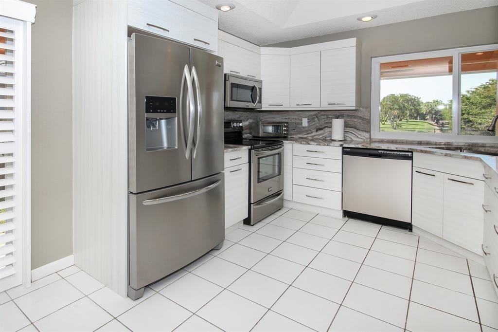 5737 Southwest 89th Way Cooper City, FL 33328 - Photo 4 of 23 a kitchen with white cabinets stainless steel appliances and window