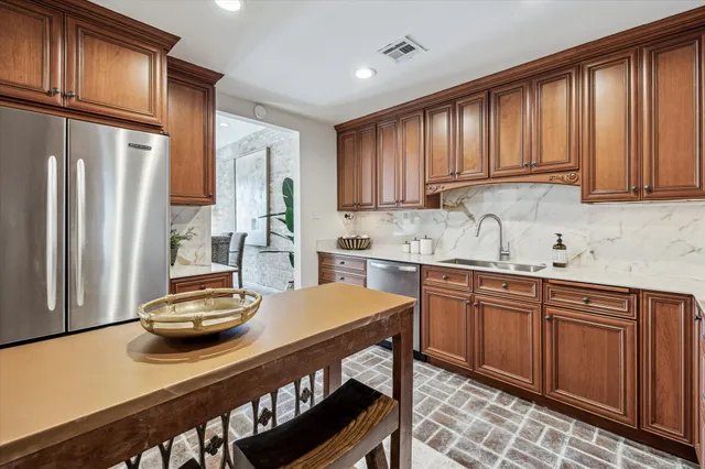 a kitchen with stainless steel appliances granite countertop a sink refrigerator and cabinets