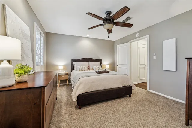 a bedroom with a bed a ceiling fan and a dresser