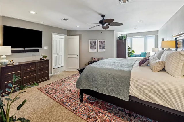 a spacious bedroom with a bed and a flat screen tv