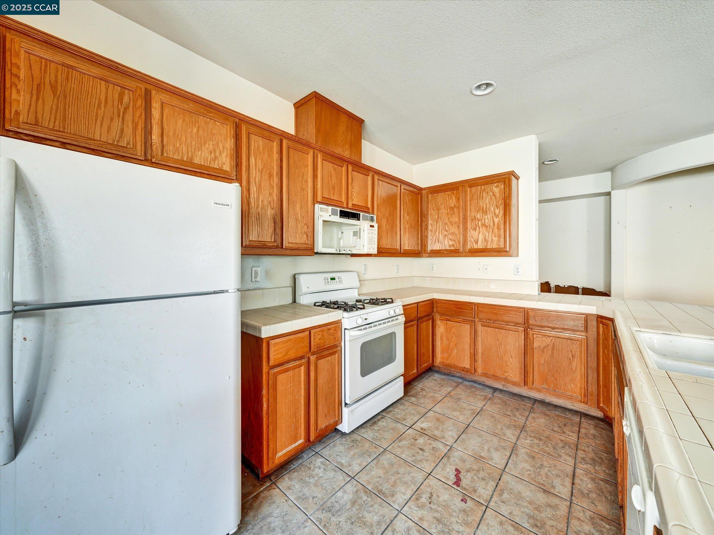 329 Brockton Place Rio Vista, CA 94571 - Photo 7 of 29 a kitchen with a refrigerator sink and cabinets