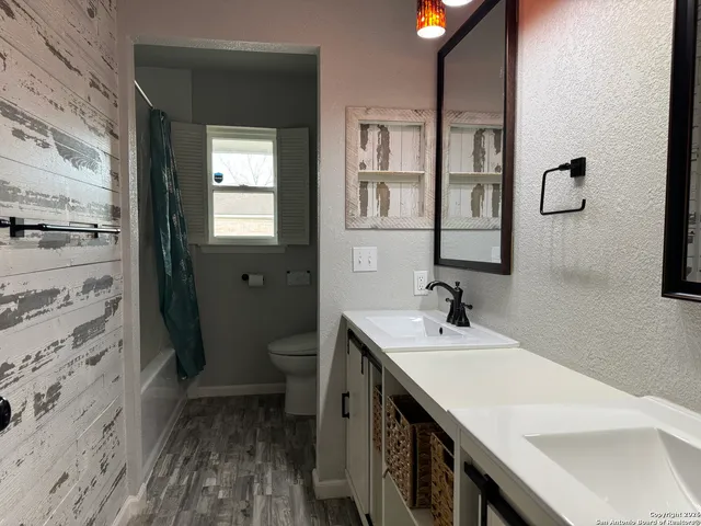 a bathroom with a sink a toilet and shower