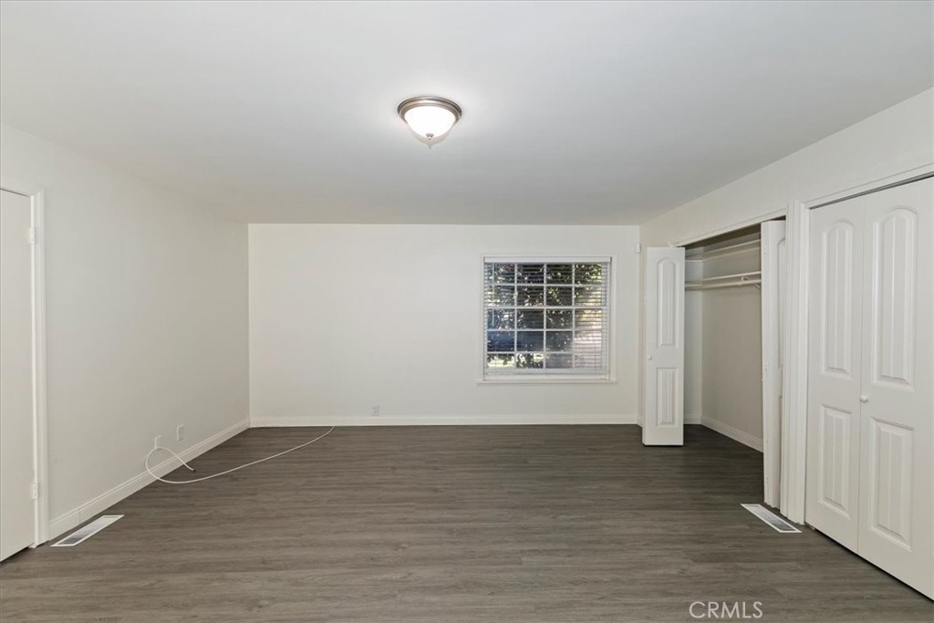 2154 Gainsborough Drive Riverside, CA 92506 - Photo 29 of 43 a view of an empty room with wooden floor and a window