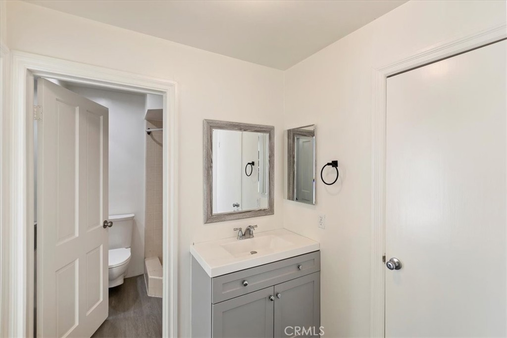 2154 Gainsborough Drive Riverside, CA 92506 - Photo 32 of 43 a bathroom with a toilet a sink a light fixture and a mirror
