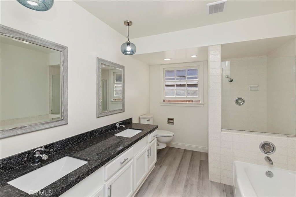 2154 Gainsborough Drive Riverside, CA 92506 - Photo 35 of 43 a bathroom with a granite countertop sink a toilet a mirror and shower