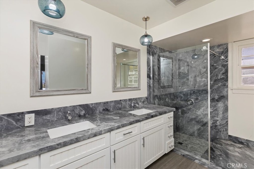 2154 Gainsborough Drive Riverside, CA 92506 - Photo 42 of 43 a bathroom with a granite countertop sink a mirror and shower