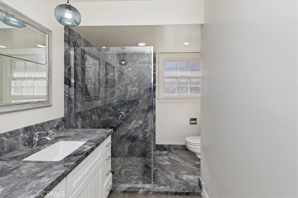 2154 Gainsborough Drive Riverside, CA 92506 - Photo 43 of 43 a bathroom with a granite countertop sink a toilet a mirror and shower
