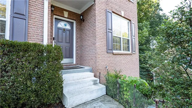 a view of a house with potted plants and a tree