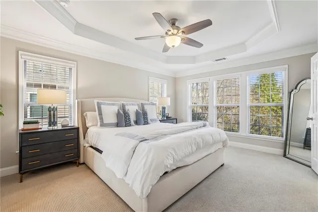 a spacious bedroom with a bed a window and a chandelier