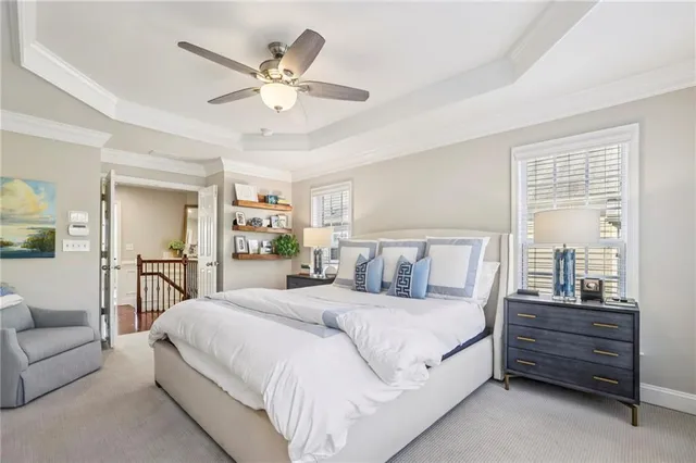 a spacious bedroom with a bed a couch and a ceiling fan