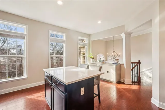 a living room with stainless steel appliances wooden floor dining table and wooden floor