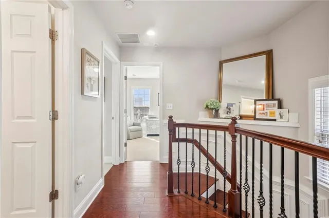 a view of a hallway with wooden floor and windows