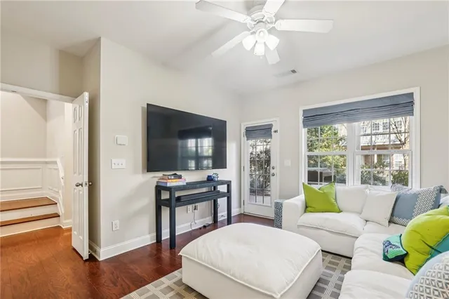 a living room with furniture a large window and a flat screen tv