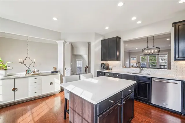 a kitchen with granite countertop a sink a stove and refrigerator