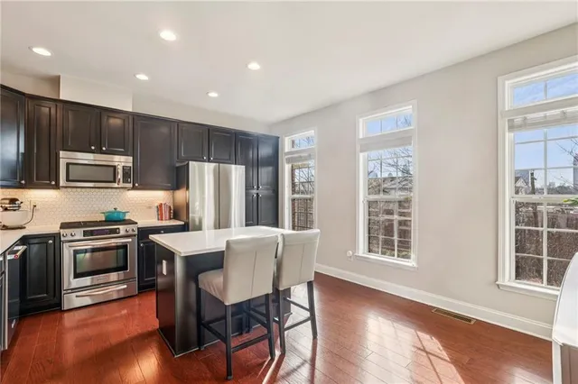 a kitchen with kitchen island wooden cabinets and stainless steel appliances