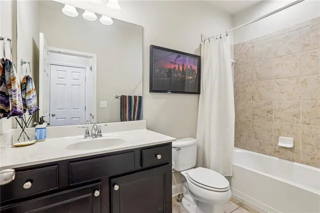 a bathroom with a sink a toilet a mirror a vanity a bath tub and shower curtain