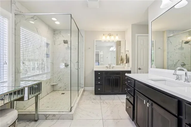 a bathroom with a granite countertop tub sink shower and mirror
