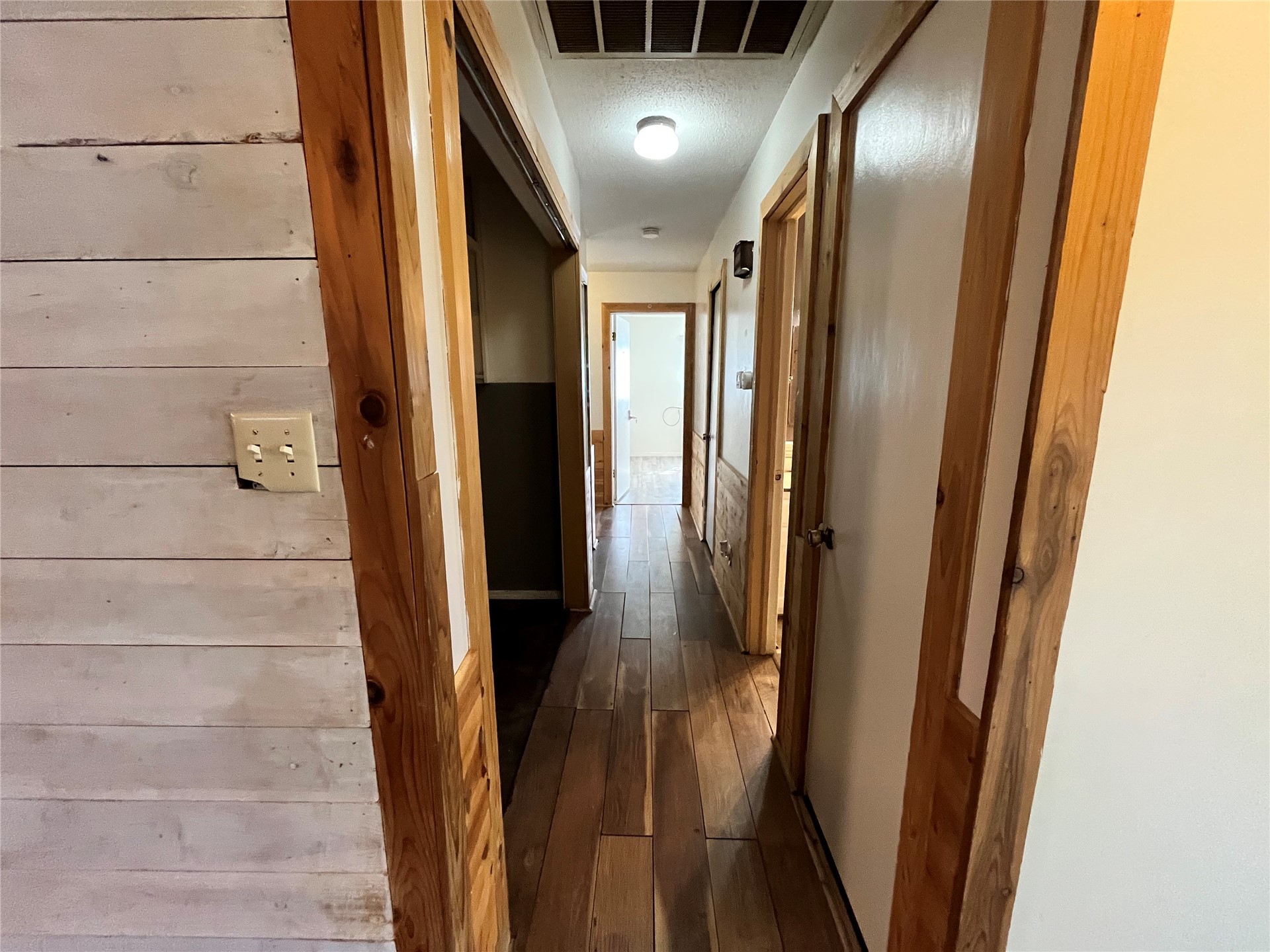 11131 215th Road Nowata, OK 74048 - Photo 18 of 47 Wood-finish flooring throughout the hallway with natural wood door frames