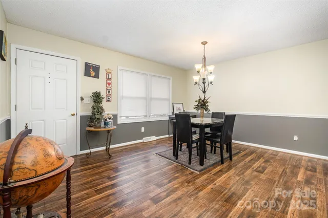 a dining room with furniture a chandelier and wooden floor