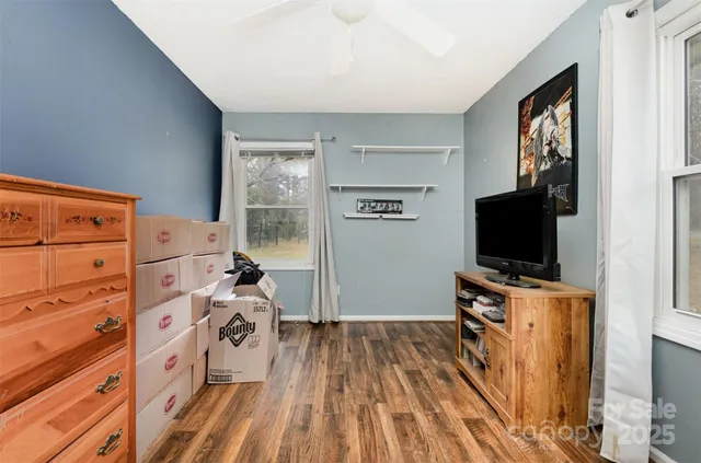 a living room with a bed furniture and a flat screen tv