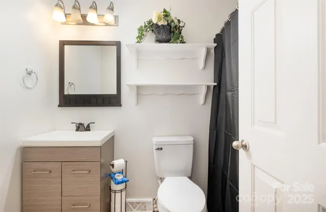 a bathroom with a sink vanity mirror and toilet