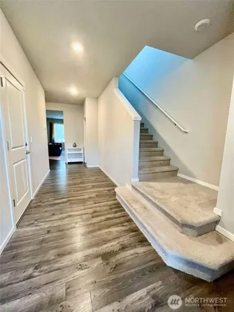 a view of a livingroom with wooden floor and stairs
