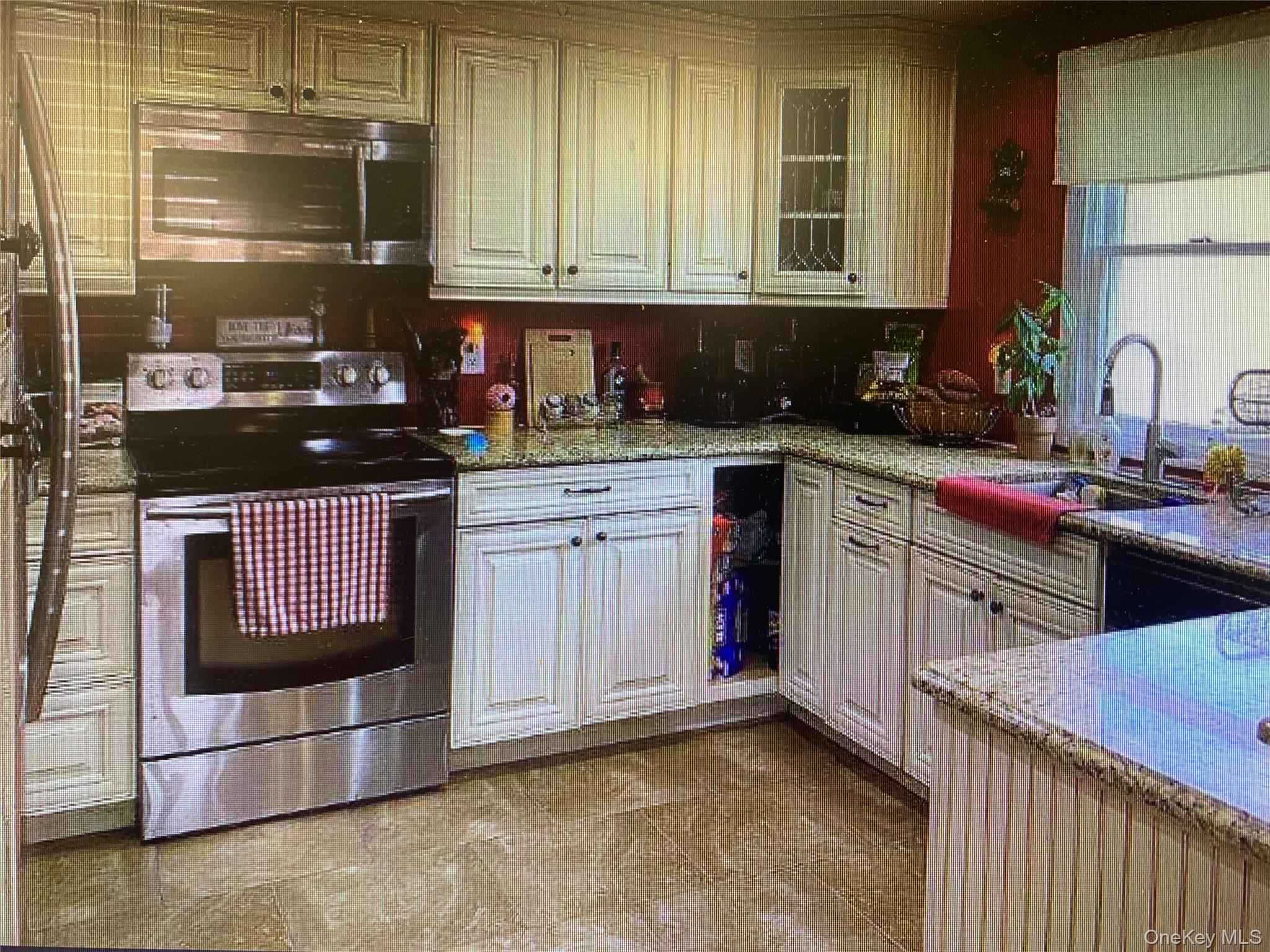 54 Robert Street Freeport, NY 11520 - Photo 6 of 11 a kitchen with stainless steel appliances granite countertop a stove a sink and a microwave