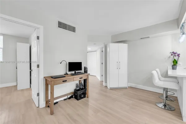 a view of kitchen with refrigerator cabinets and wooden floor
