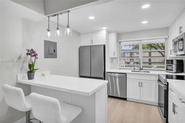 a kitchen with white cabinets stainless steel appliances and sink
