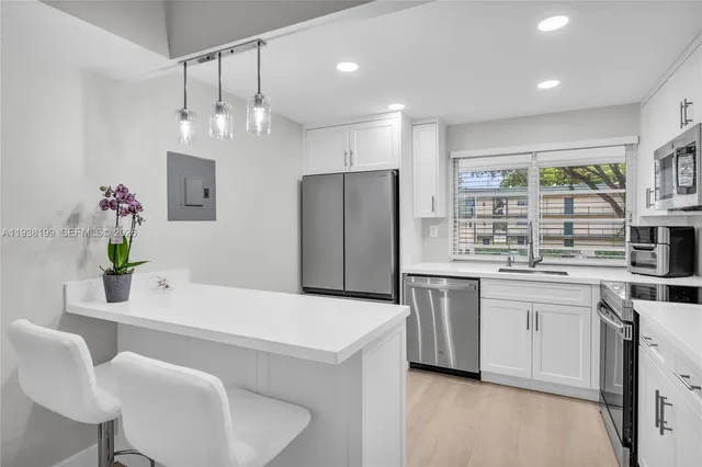 a kitchen with white cabinets stainless steel appliances and sink