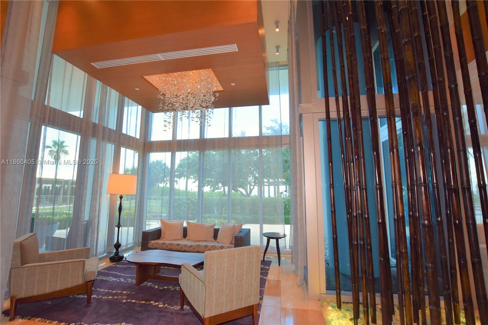 6899 Collins Avenue, Unit 1905 Miami Beach, FL 33141 - Photo 20 of 29 a living room with large windows and a table