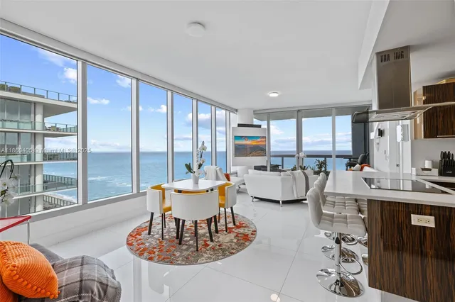 a living room with furniture large window and glass table