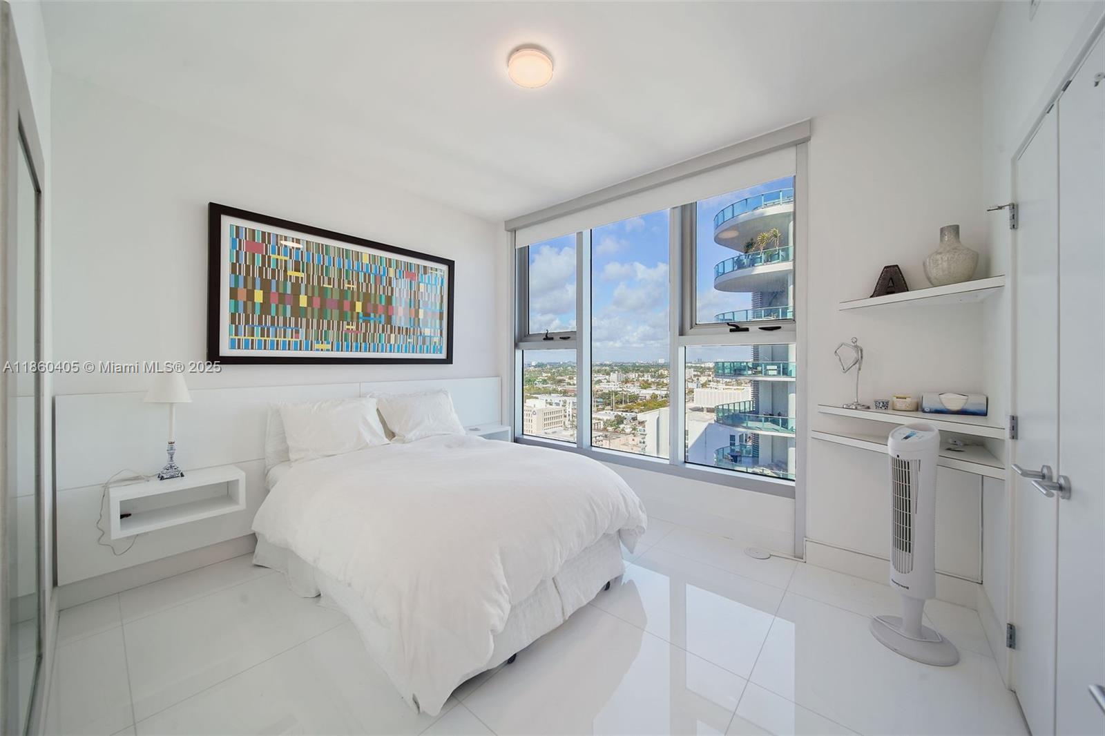 6899 Collins Avenue, Unit 1905 Miami Beach, FL 33141 - Photo 9 of 29 a bedroom with a bed and a large window