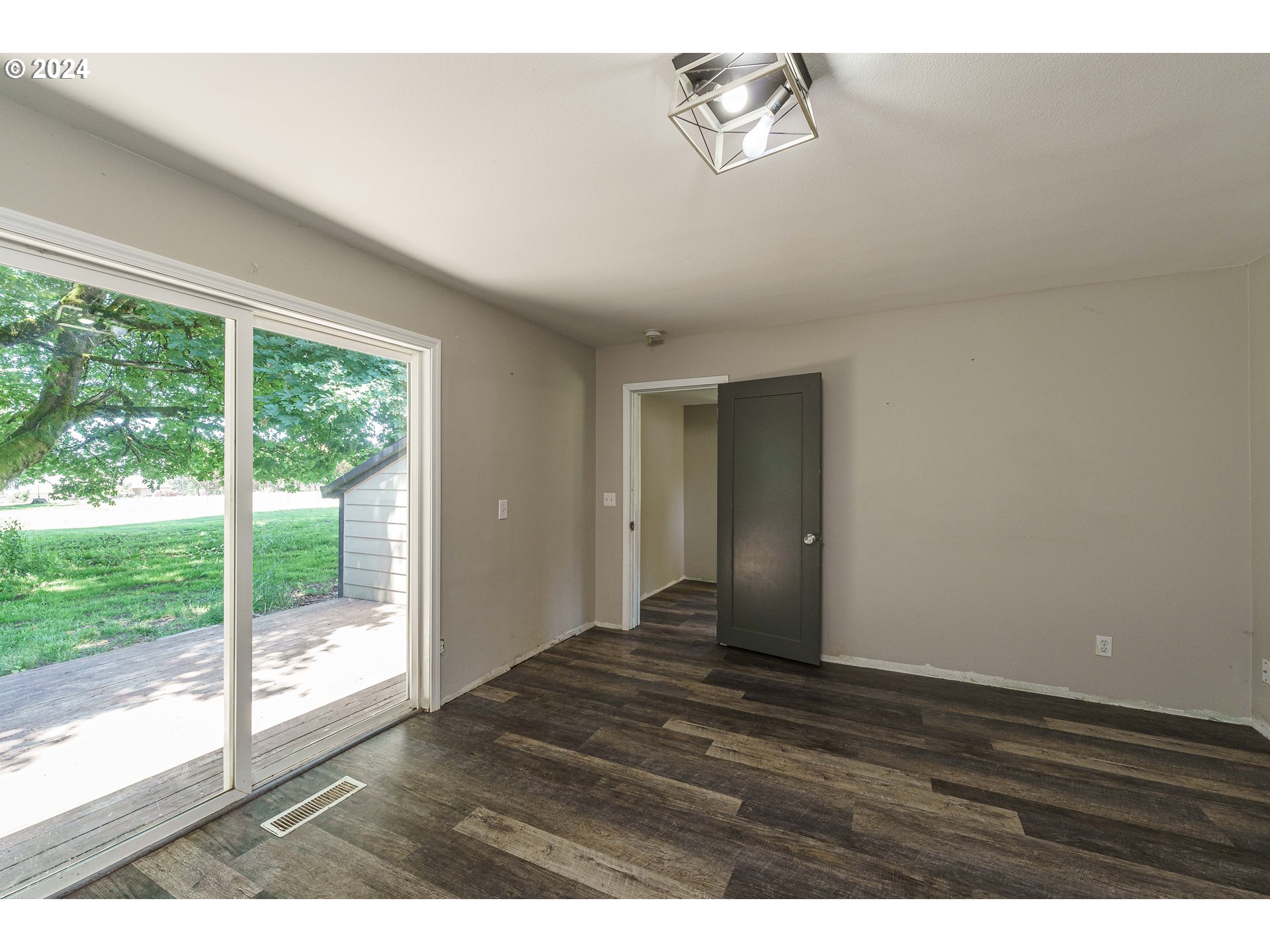 19625 Southeast Jacoby Road Sandy, OR 97055 - Photo 11 of 47 a view of an empty room with wooden floor and a window