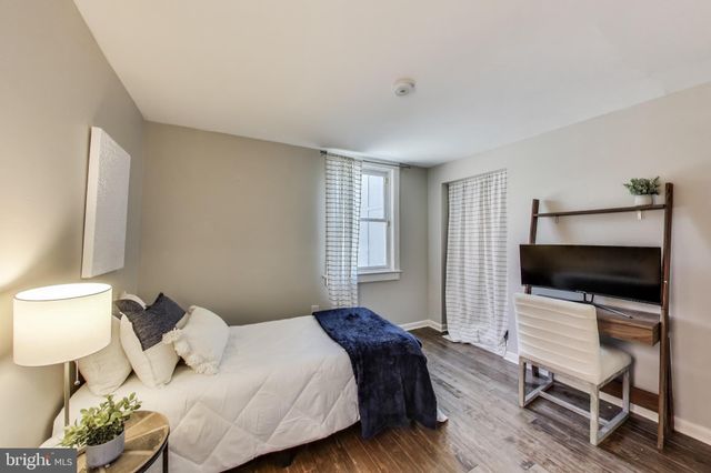 a bedroom with a bed tv and a chair