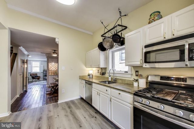 a kitchen with stainless steel appliances a stove a sink and a wooden floors