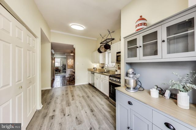 a kitchen with stainless steel appliances granite countertop a lot of cabinets and wooden floor