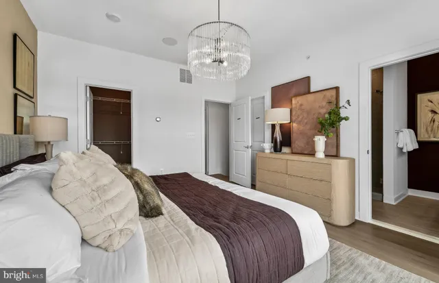 a bedroom with a large bed and a chandelier