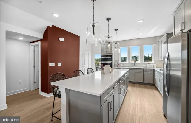 a kitchen with kitchen island a counter top space a sink stainless steel appliances and cabinets