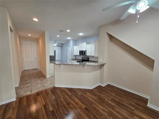 a view of kitchen with wooden floor and electronic appliances