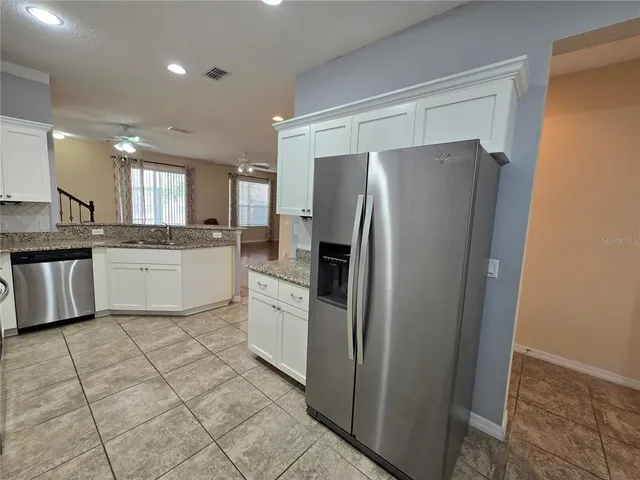 a kitchen with stainless steel appliances granite countertop a refrigerator sink and cabinets
