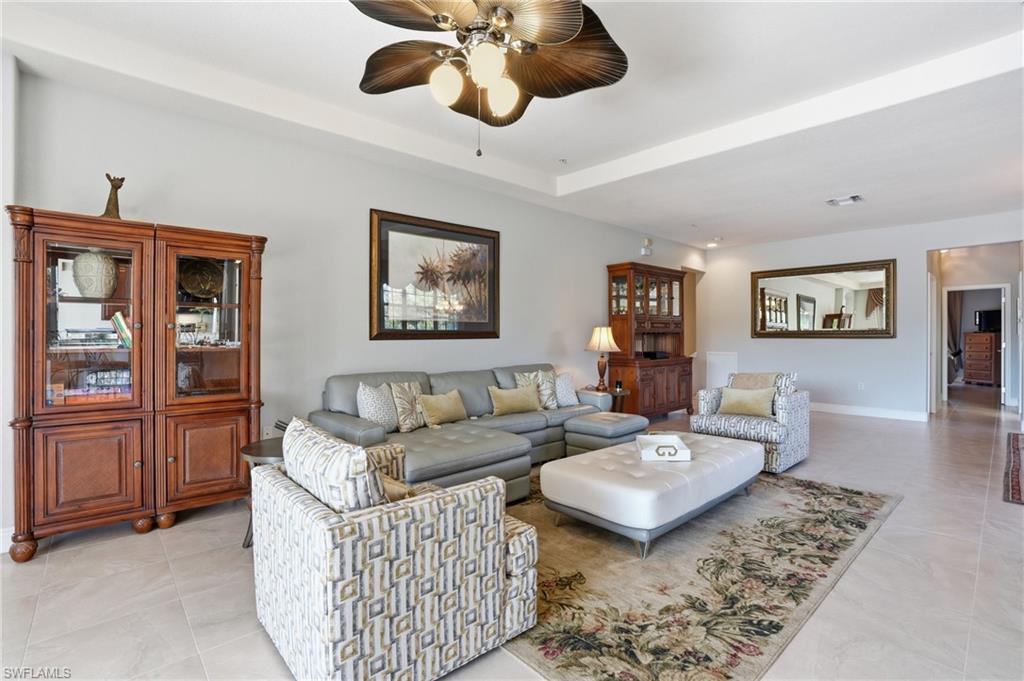 4620 Winged Foot Court, Unit 201 Naples, FL 34112 - Photo 13 of 44 Living room with a ceiling fan and a tray ceiling