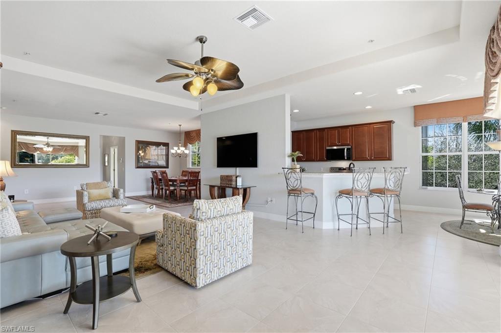 4620 Winged Foot Court, Unit 201 Naples, FL 34112 - Photo 15 of 44 Living area featuring ceiling fan, suspended lighting, and a raised ceiling